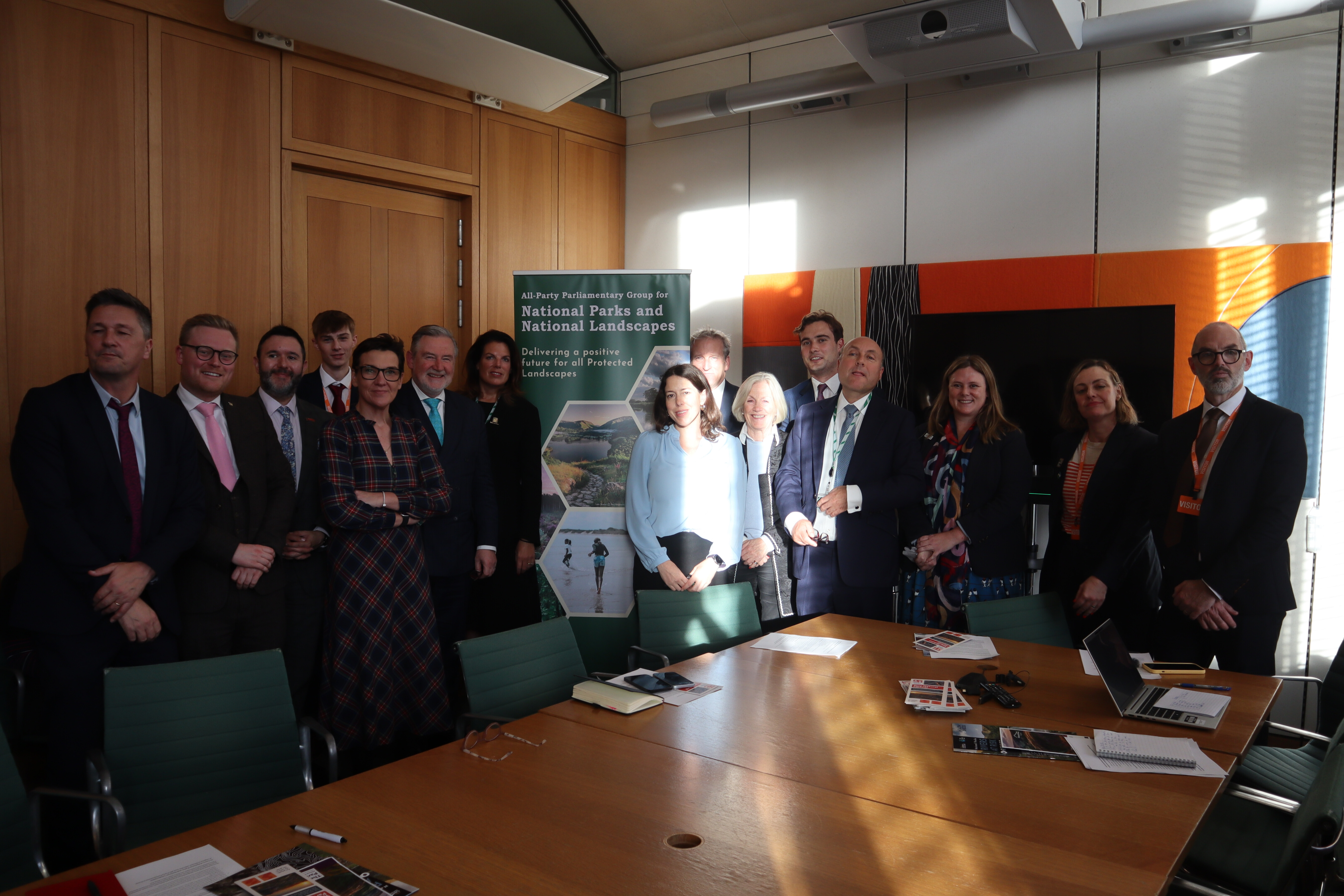 Attendees at the APPG launch event. A group of people stand in front of a banner with text that reads, "All-Party Parliamentary Group for National Parks and National Landscapes."
