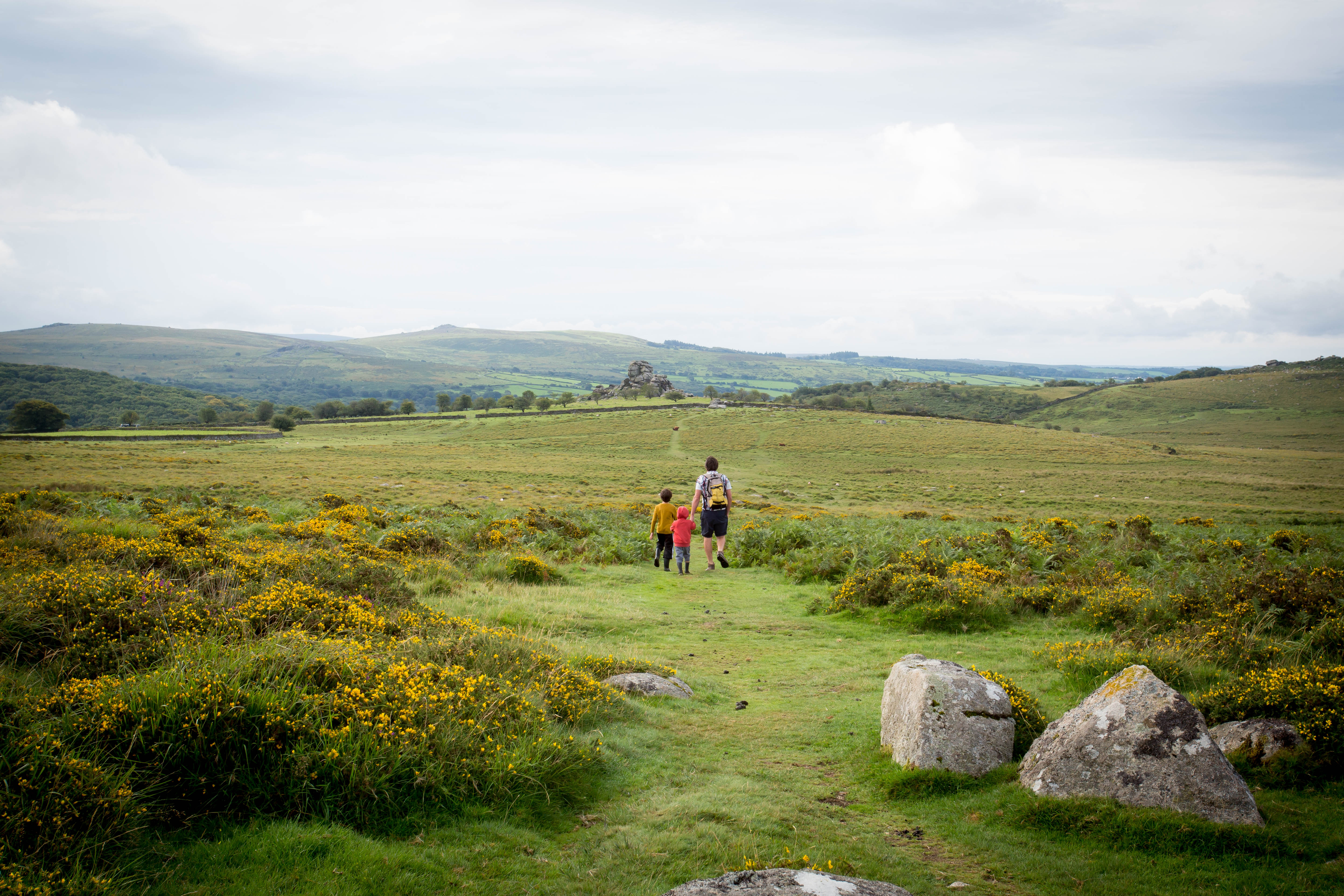 Two people walking away in a moorland landscape, Dartmoor National Park
